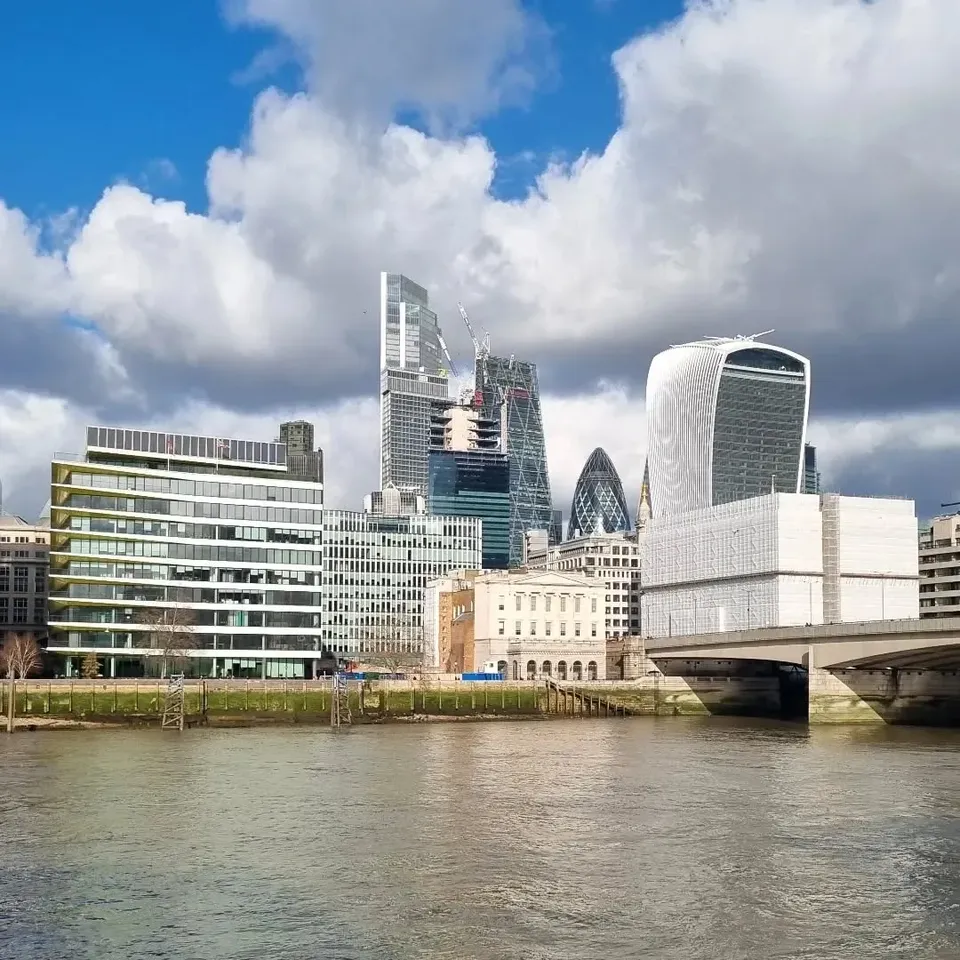 The Thames and City of London skyline under big white clouds