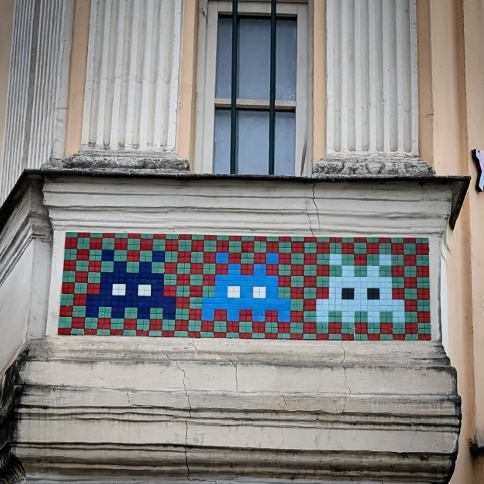 Space Invaders mosaic street art on a classical building