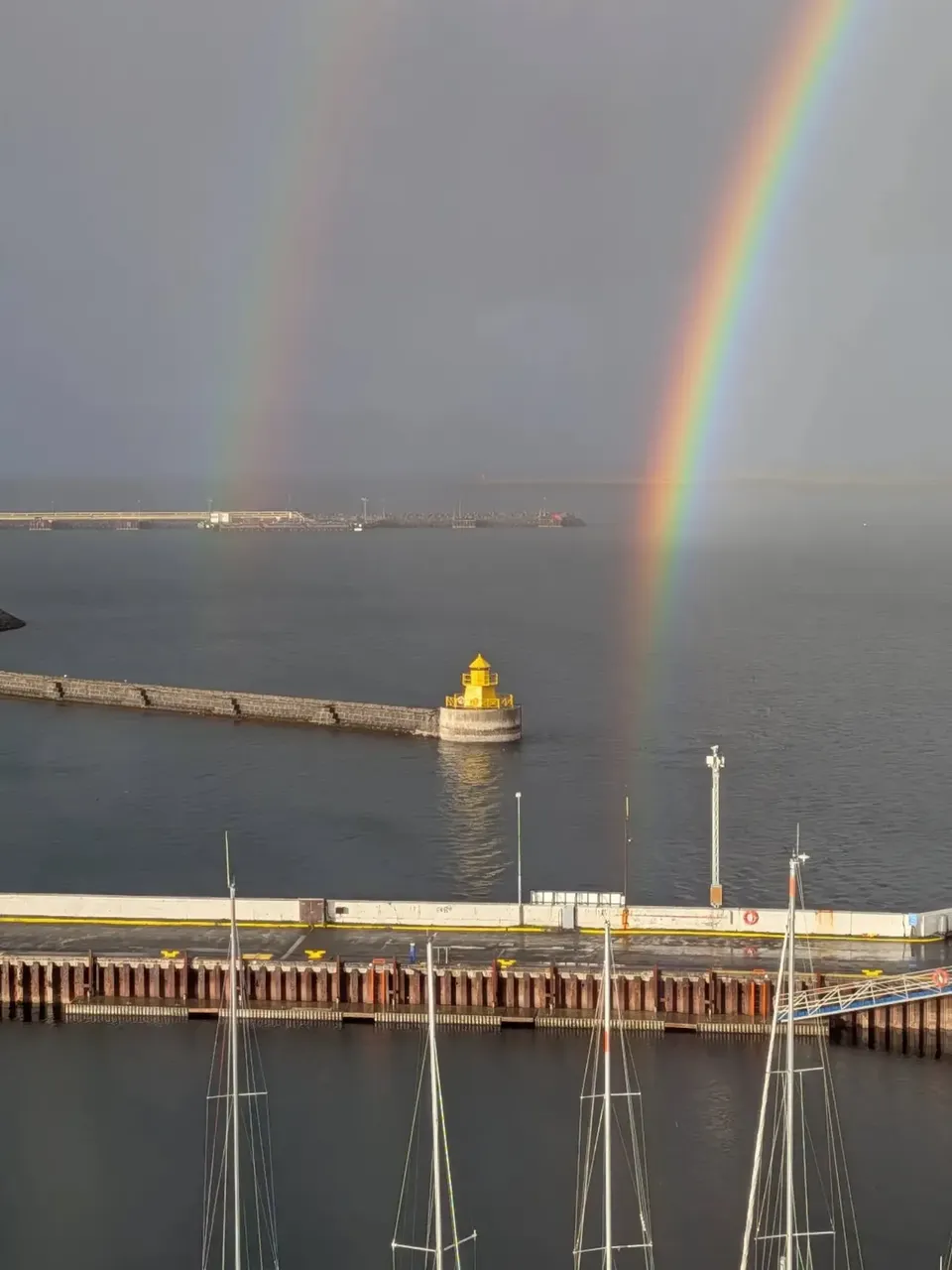 A double rainbow above the harbour wall