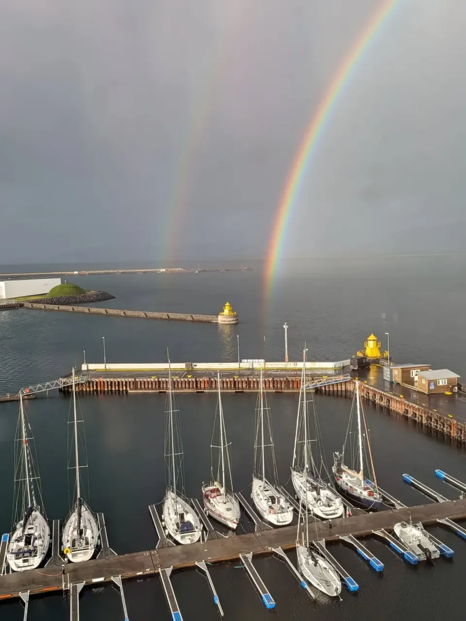 A rainbow over boats moored in the harbour